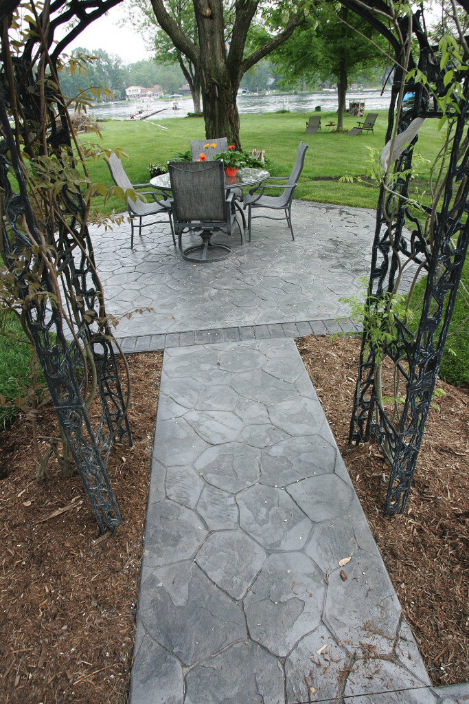 Patio in Random Stone with Lt.Gray color hardner and Dk. Gray antique. Brick stamped border in Charcoal